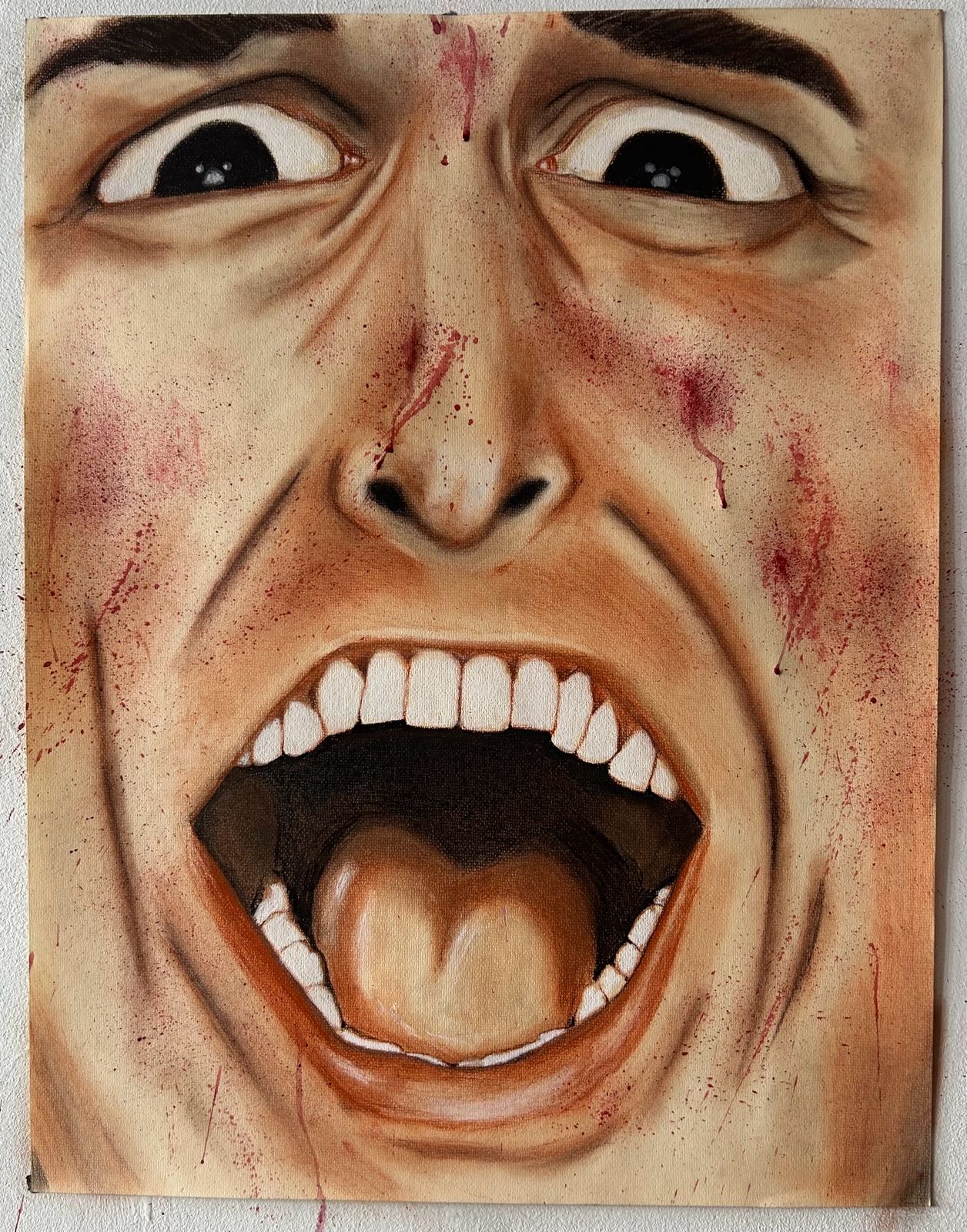 Dibujo en carboncillo y pastel de un rostro masculino en primer plano gritando, con los ojos oscuros muy abiertos y la boca abierta, salpicado de pintura roja.